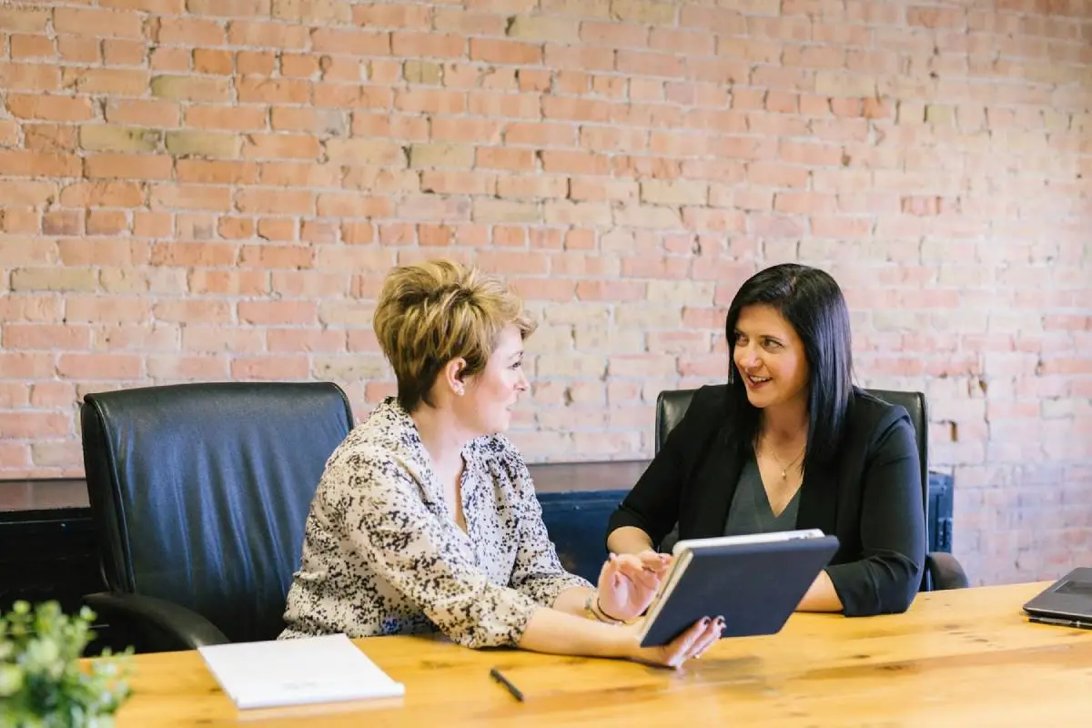 two people sitting at a desk discussing the role of the change consultant