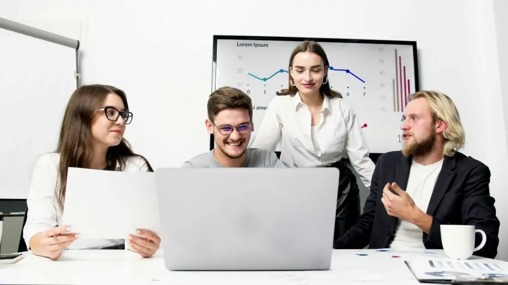 four people working together on a project looking happy with their own roles.