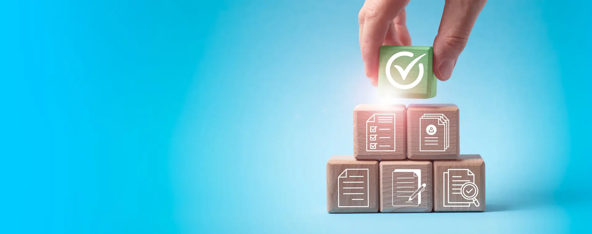 A hand stacking blocks in a blue background