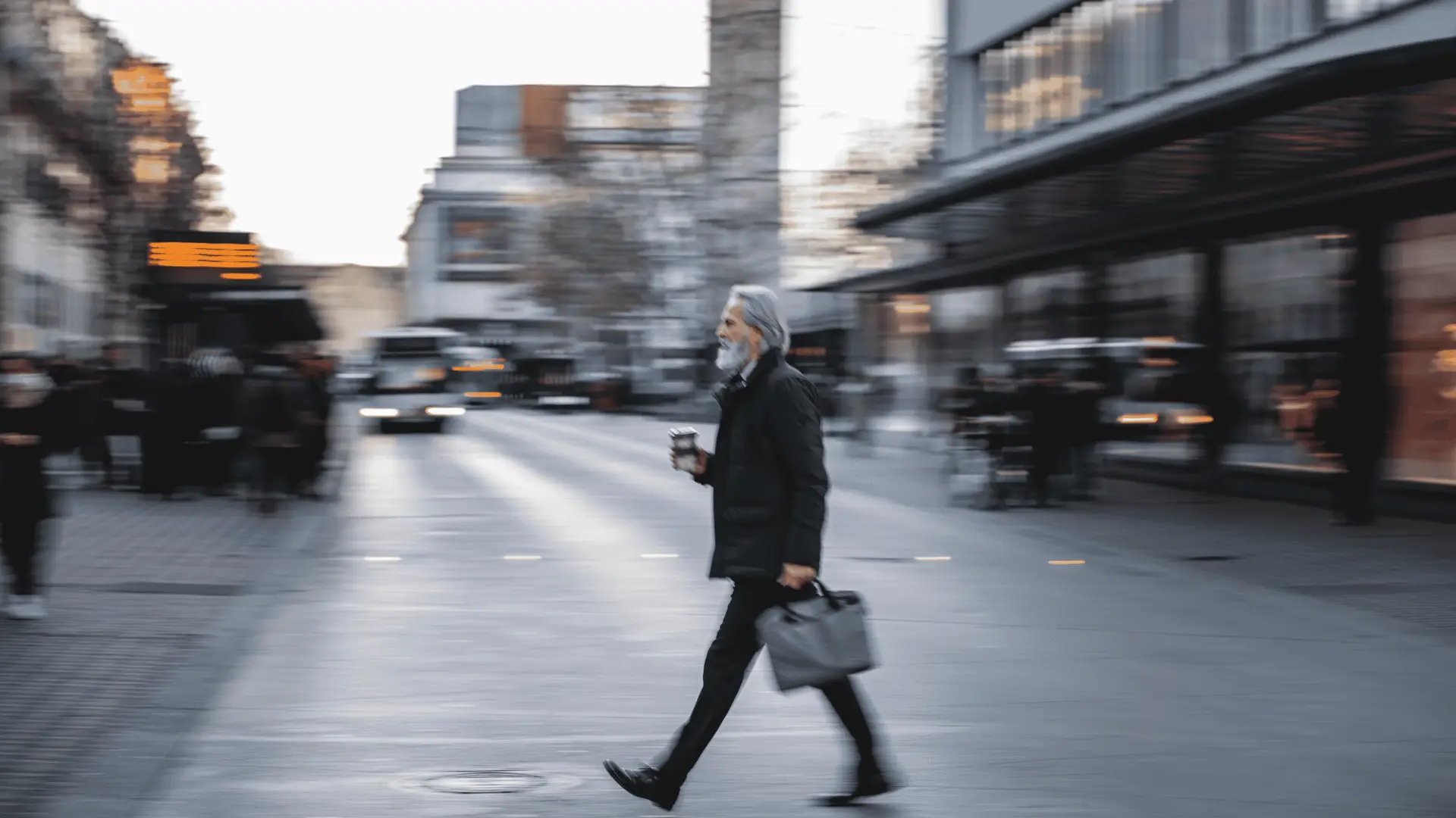 Focused business professional standing still while others rush past, symbolising the tension between speed and thoughtful leadership in transformation.